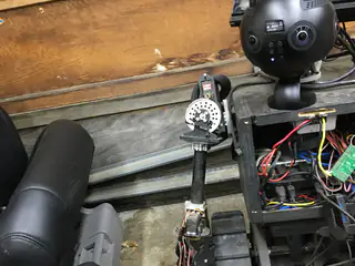 High rear angle showing the spherical camera, open wiring compartment, and left arm beside the chassis.