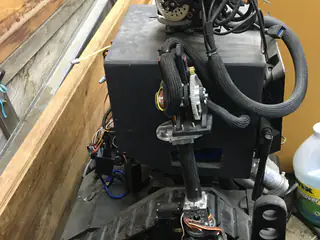 Right-side view of the robot enclosure with a braided cable loop connecting the shoulder and arm.