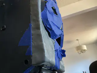 Low side close-up of the robot's gray temporary chest enclosure and crumpled blue tape features.