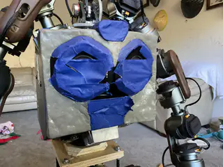Frontal close-up of the robot's temporary chest enclosure covered with gray and blue painter's tape.