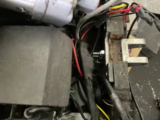 Close-up of red and black motor wiring beside a U-shaped metal bracket inside the chassis.