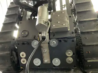 Low rear view of the motor and bolted drive assembly positioned between the robot's tank treads.