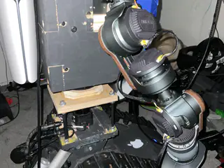 Flash-lit side view of the robot's articulated arm joints mounted beside a black body enclosure.