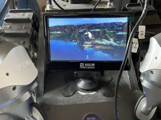 MakerBro monitor between the robot's arms displaying a lake-and-mountain desktop wallpaper.