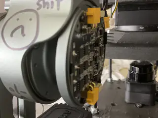 Circular circuit board beside a gray joint bearing a hand-drawn face and handwritten note.