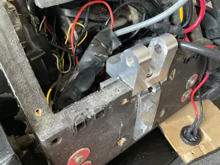 Angled close-up of a newly mounted metal clamp and upright bracket inside the chassis.