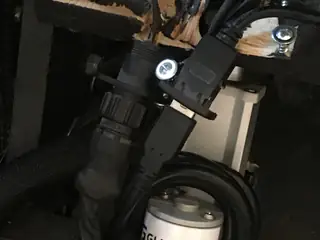 Dim angled close-up of a connected depth camera and cables inside the robot chassis.
