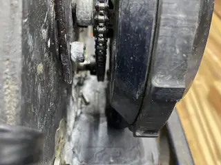Close side view of a chain drive running between the robot tread and metal chassis.
