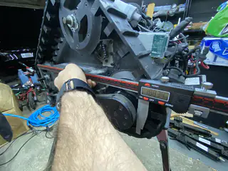 Close angled view shows a hand holding a digital caliper across the tread frame.