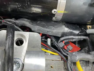 Close-up of a cylindrical drive motor secured beside a machined aluminum bracket.