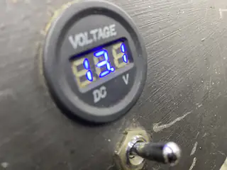 Round digital voltage gauge on the chassis displays a 13.1-volt reading.