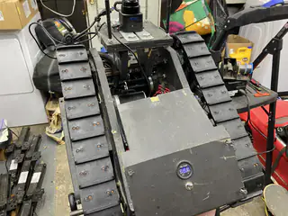 Nearly assembled tracked base in the workshop with sloped front panel and exposed upper frame.
