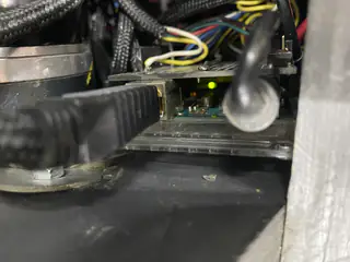 Ethernet cable plugged into an illuminated controller board deep inside the robot chassis.