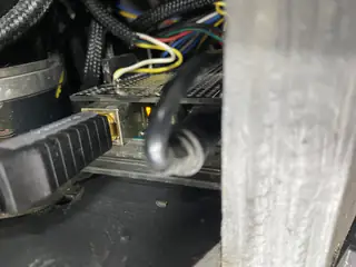 Ethernet cable plugs into a partially obscured circuit board amid bundled wiring inside the chassis.