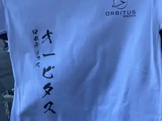 White Orbitus Robotics shirt printed with vertical Japanese lettering across the front.