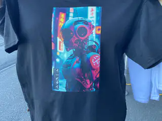Black shirt printed with colorful neon robot artwork in a futuristic city scene.