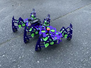Closer view of the vivid purple walking robot with articulated legs spread outward.