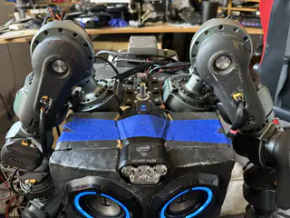 High-angle close-up of R.O.B.’s head, shoulder motors, blue tape, and exposed top wiring.