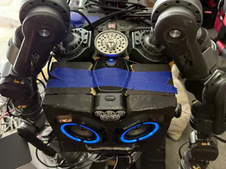 Overhead view of R.O.B.’s speaker face beneath twin shoulder joints and a central metal gear.