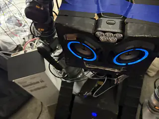 Angled close-up of R.O.B.’s illuminated speaker face with the left arm and track partially visible.