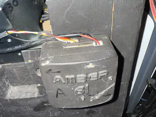 Close-up of a black robot body panel embossed AMBER A61 and marked with handwritten characters.