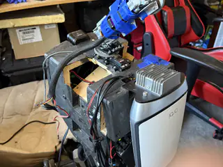 Right-side upper-body view showing R.O.B.’s gray motor housing, taped mechanism, cables, and open chassis.