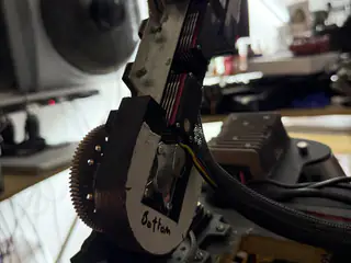 Close side view of a geared vertical bracket labeled Bottom between R.O.B.’s shoulder assemblies.