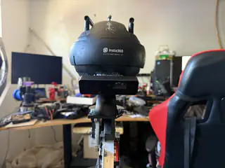 Rear view of the black spherical camera mounted atop R.O.B.’s narrow neck mechanism.