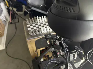 High rear view over R.O.B.’s spherical head toward a fully arranged chessboard.