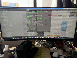 Ultrawide monitor filled with code, logs, tables, and highlighted status panels.