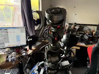 Closer rear view of the spherical camera head and stacked neck joints against the workbench.