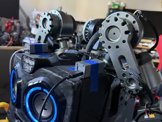 Close front-side view of R.O.B.’s blue speaker face, shoulder plates, and exposed arm joint.