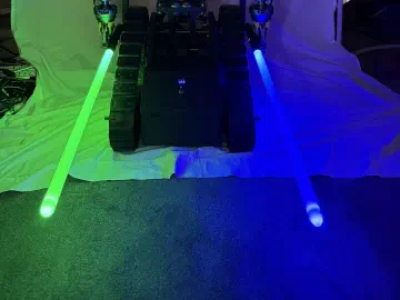 R.O.B. facing forward with one glowing green lightsaber and one glowing blue lightsaber